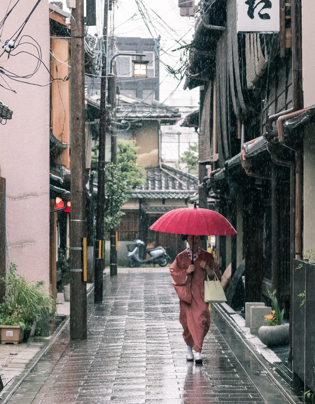 Geisha con l'ombrello sotto la pioggia di Kyoto