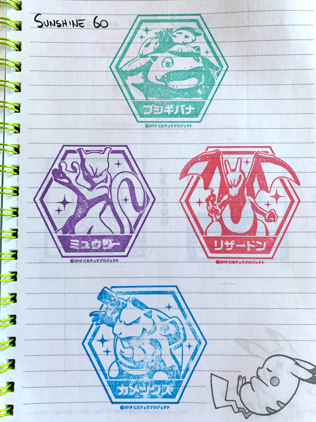 Timbri colorati dei Pokémon raccolti sulle pagine di un quaderno.
